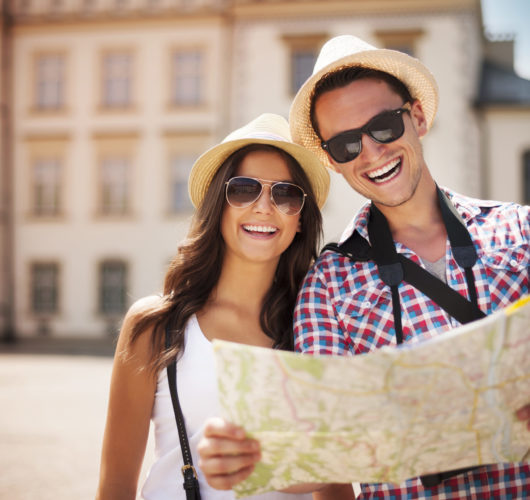 Happy tourists couple holding map
